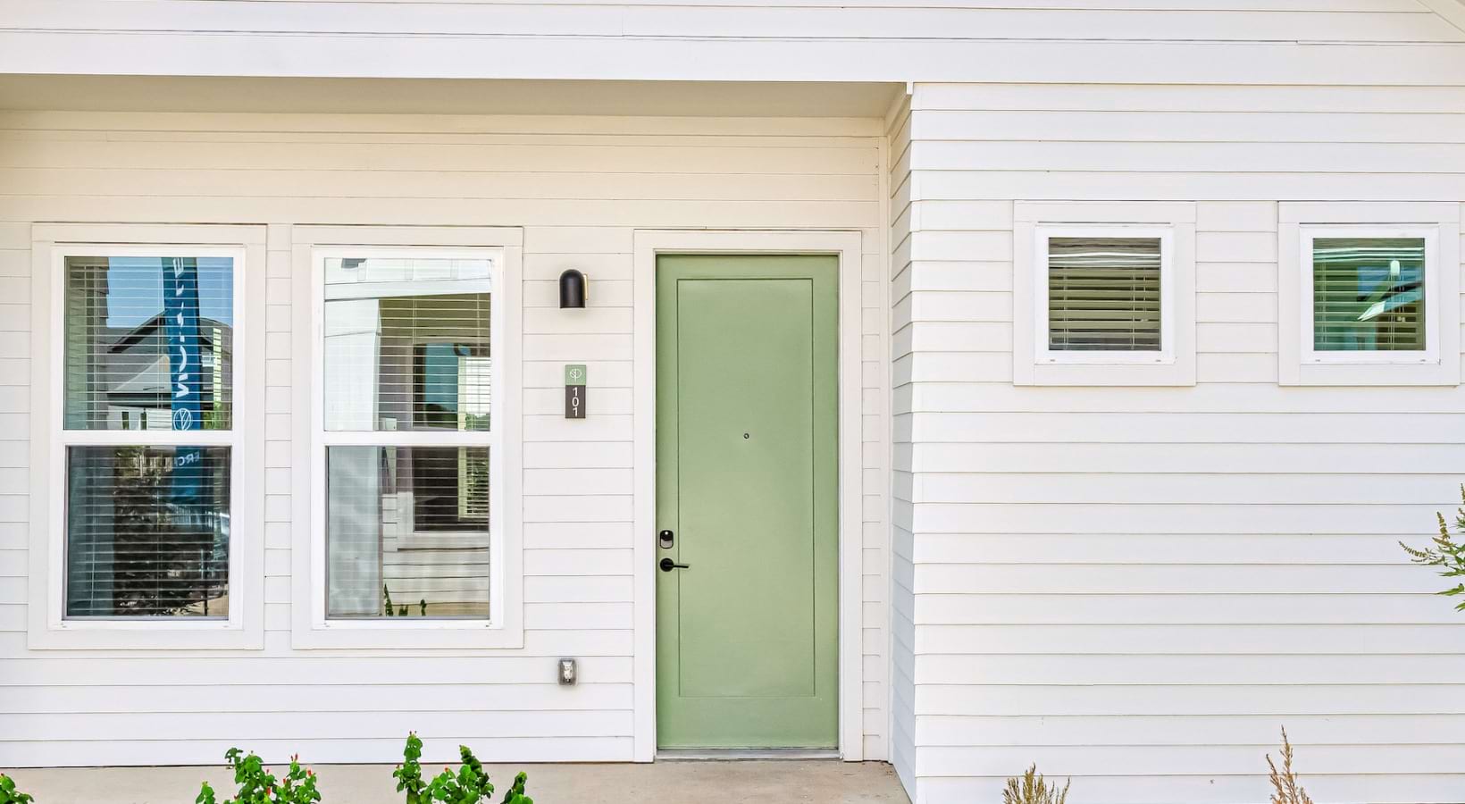 White home with sage green door