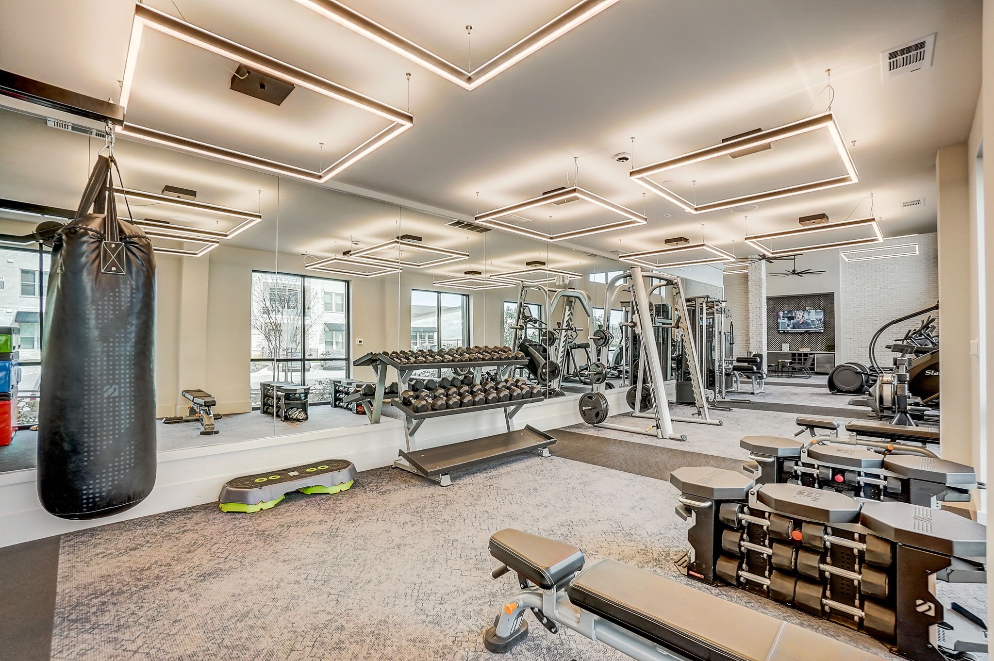 a gym with weights and a punching bag on the wall