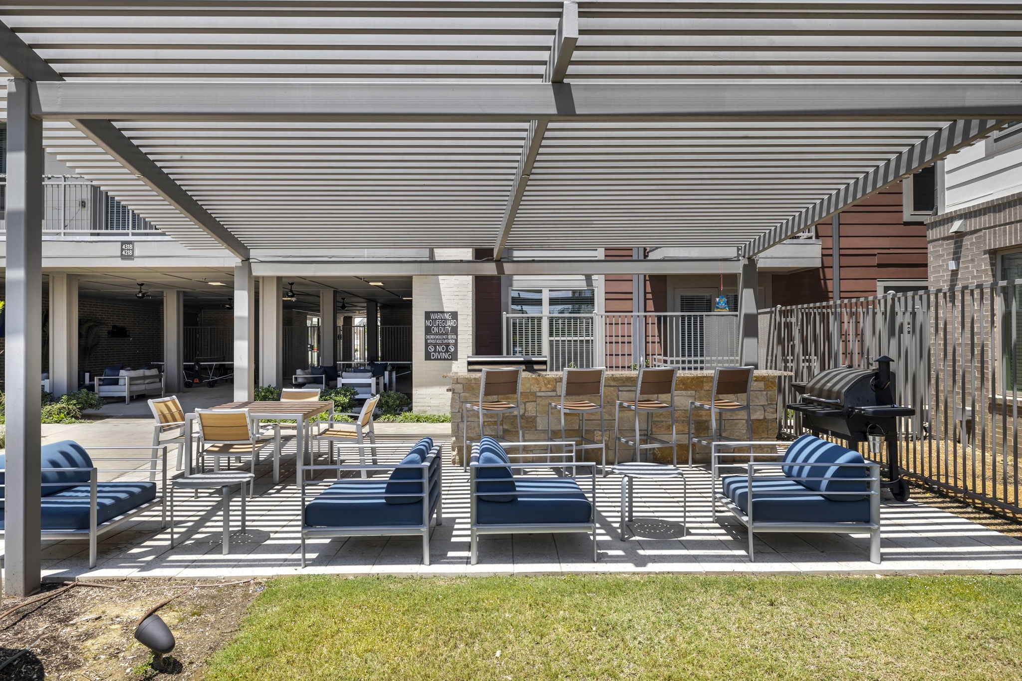 26 at City Point - A patio with blue chairs and a white awning