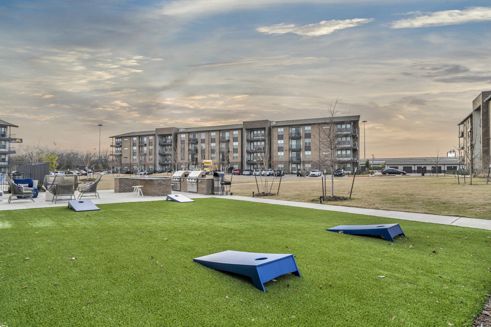 A grassy area with a blue object in the middle and apartment buildings in the background. at Axis Grand Crossing