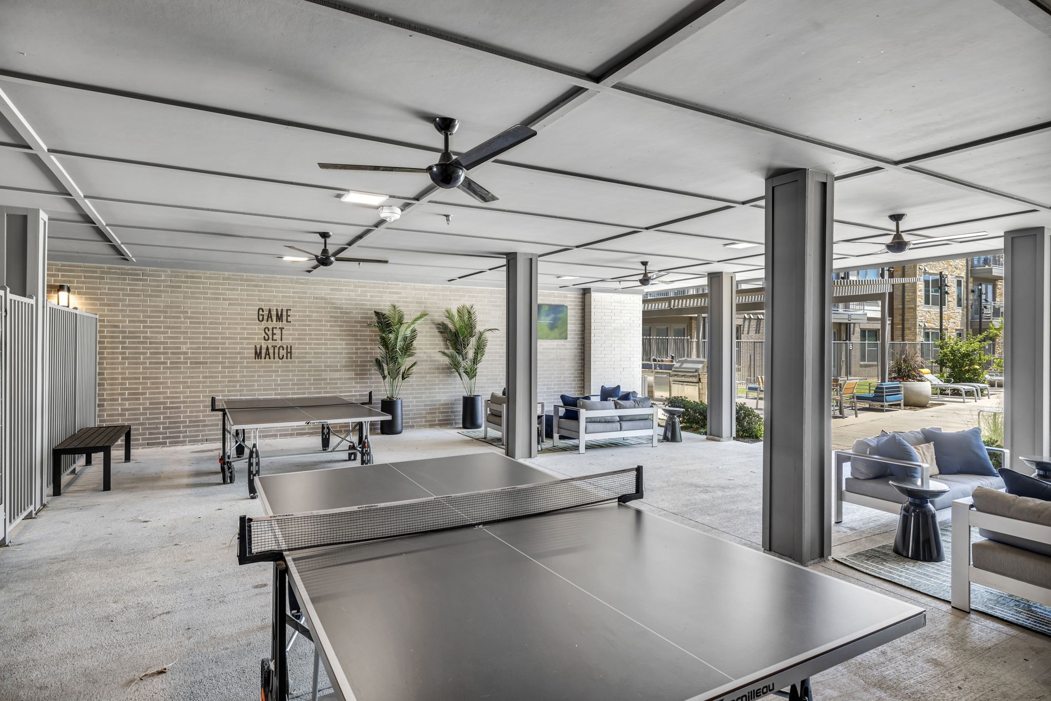 26 at City Point - A ping pong table is in the middle of a room with a sign that says "Game Set Match" on the wall behind it