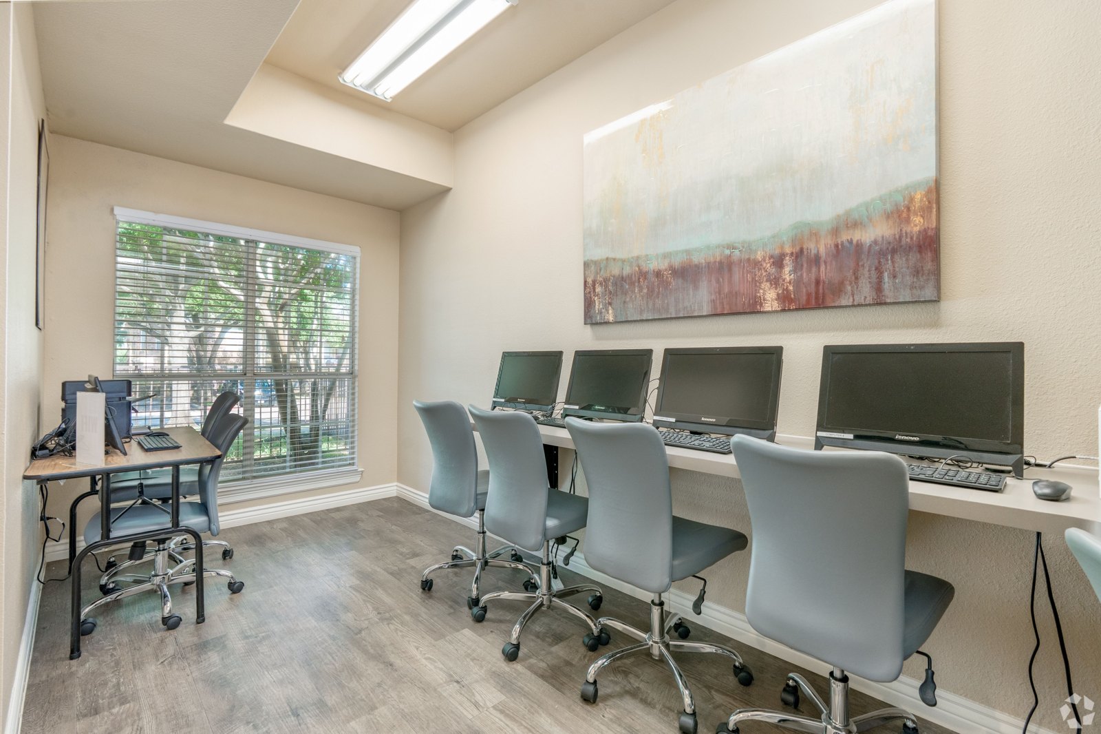 A room with a desk, chairs, and computers. at Ash Lane Apartment Homes