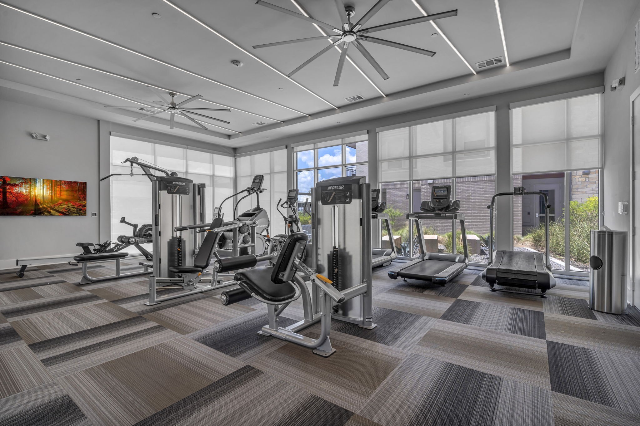 26 at City Point - A spacious gym with a variety of equipment and a ceiling fan