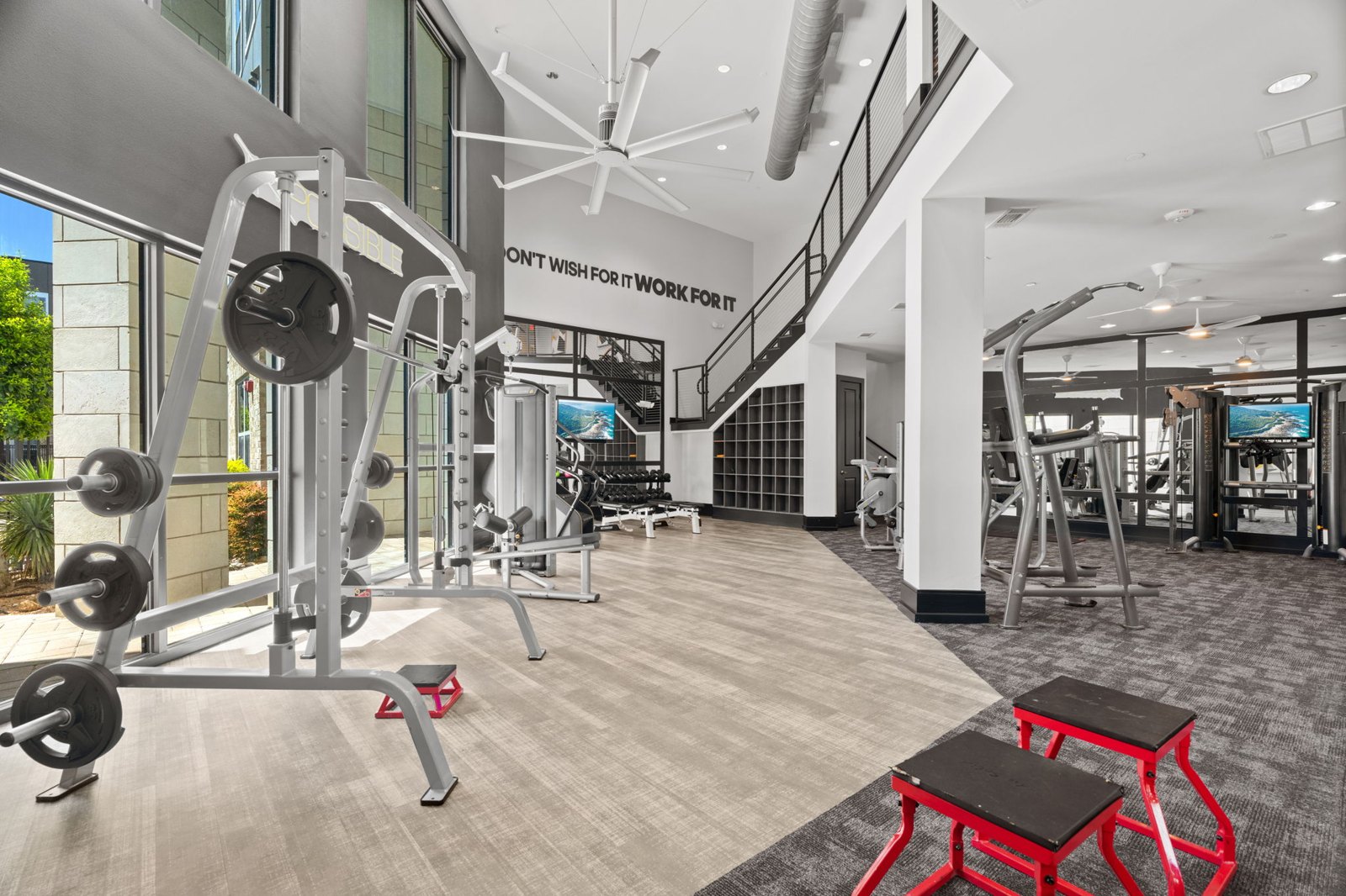 A gym with a variety of equipment including a weight bench and a treadmill. at Axis at Watters Creek