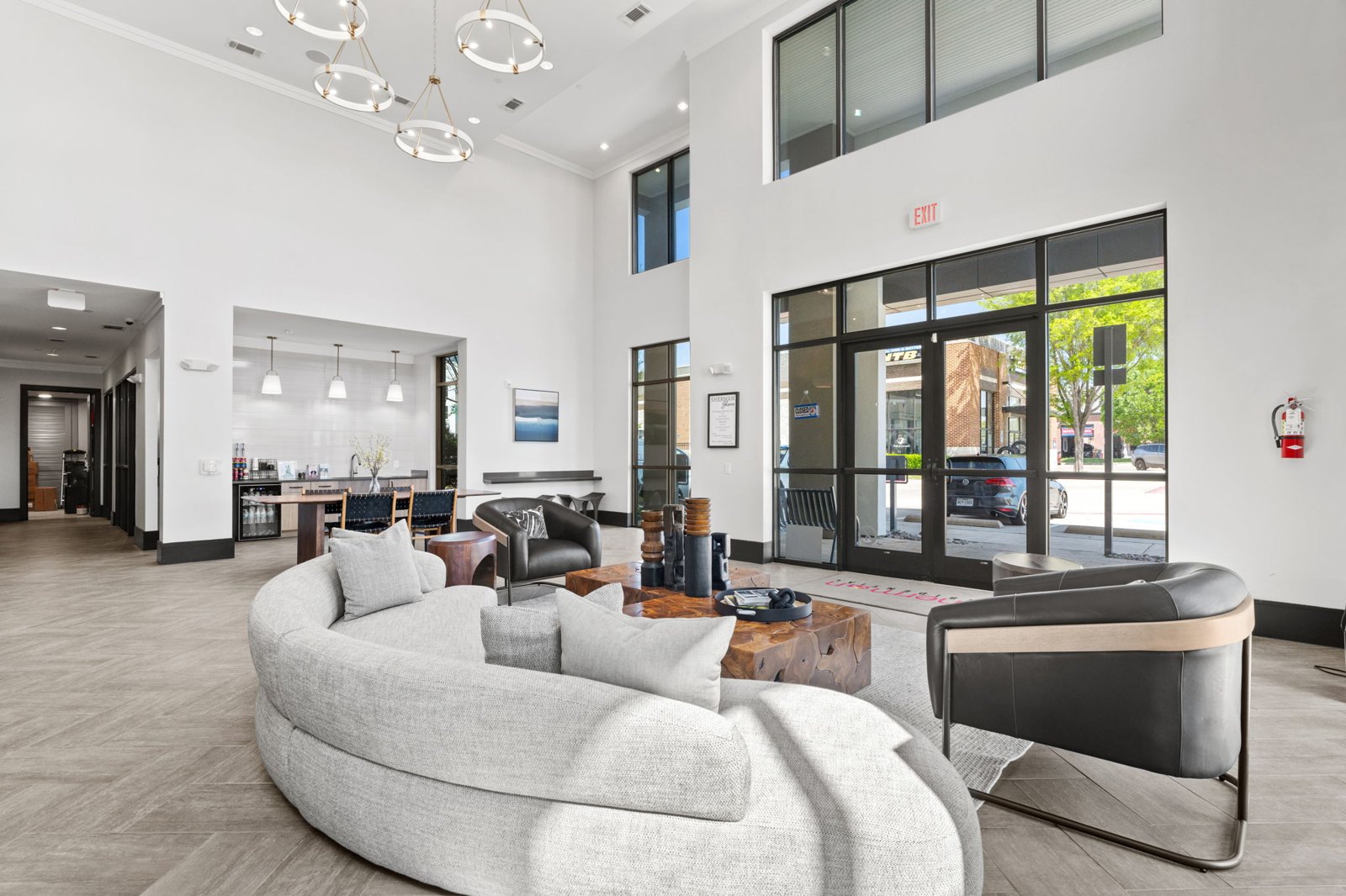 A modern living room with a curved sofa and a fireplace. at Axis at Watters Creek