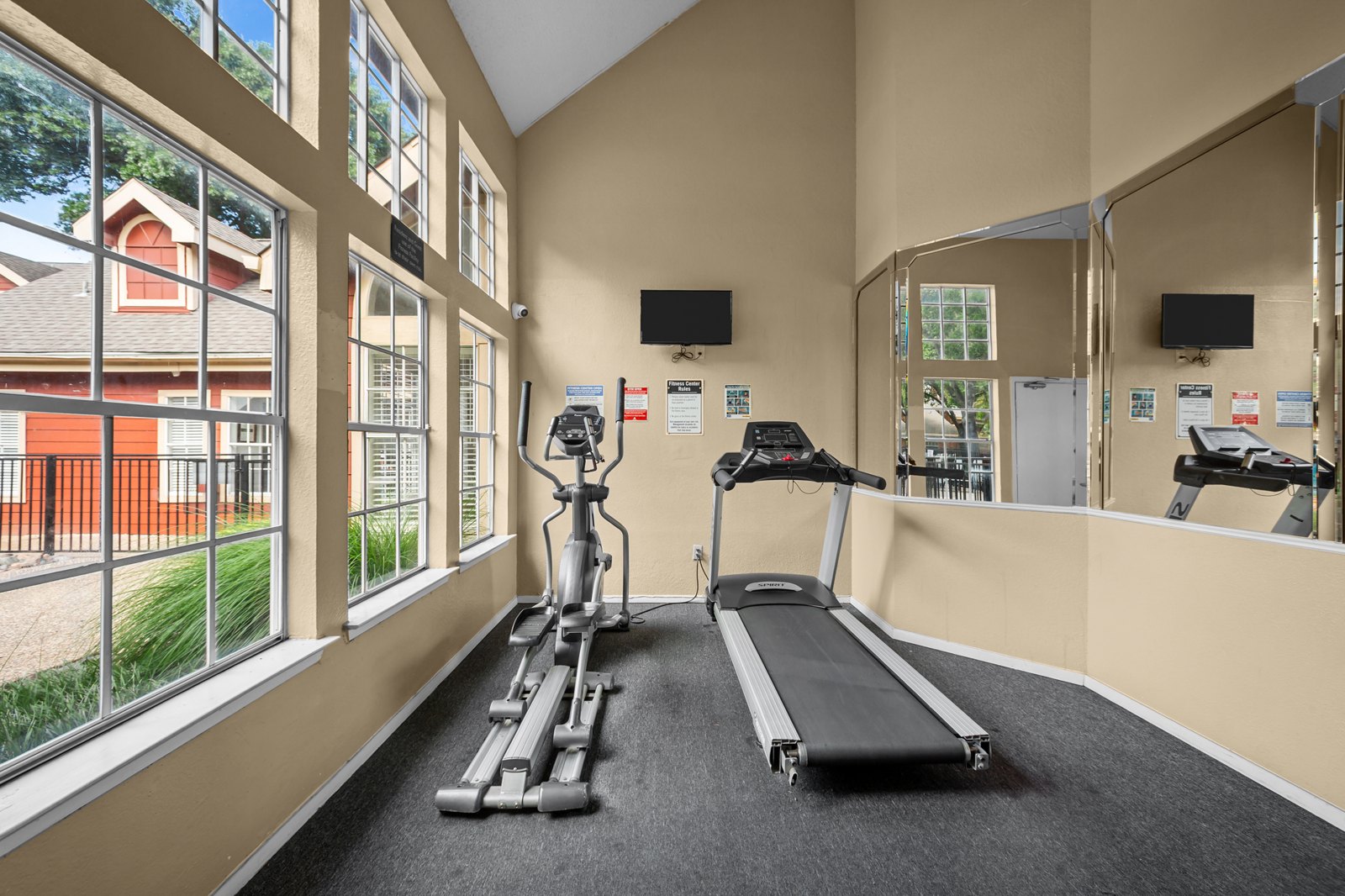 A gym with treadmills and exercise bikes. at Bravo Apartment Living