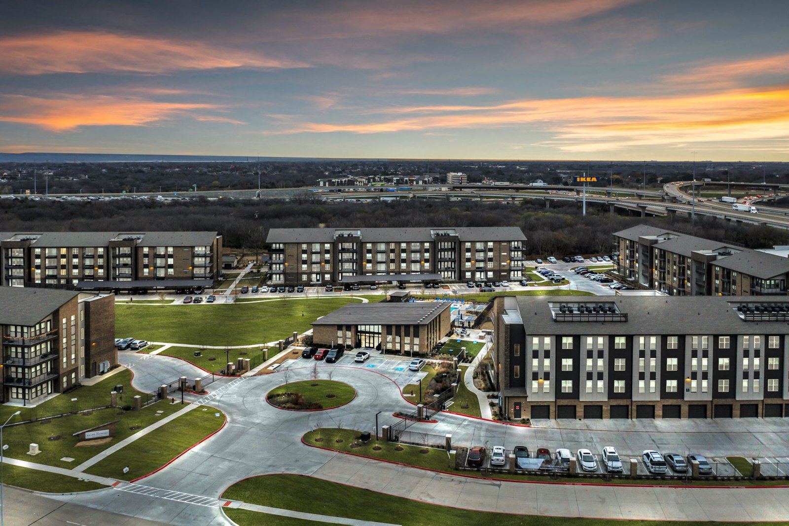 A large, modern building complex with a parking lot in front. at Axis Grand Crossing