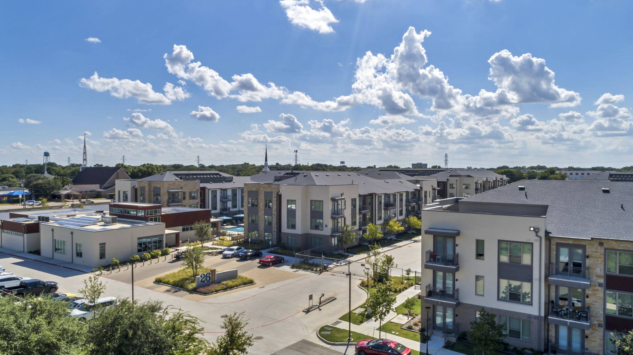 26 at City Point - A sunny day at a residential complex with multiple buildings and cars parked
