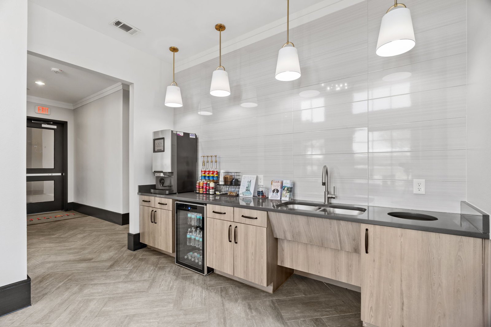 A kitchen with a refrigerator, sink, and cabinets. at Axis at Watters Creek