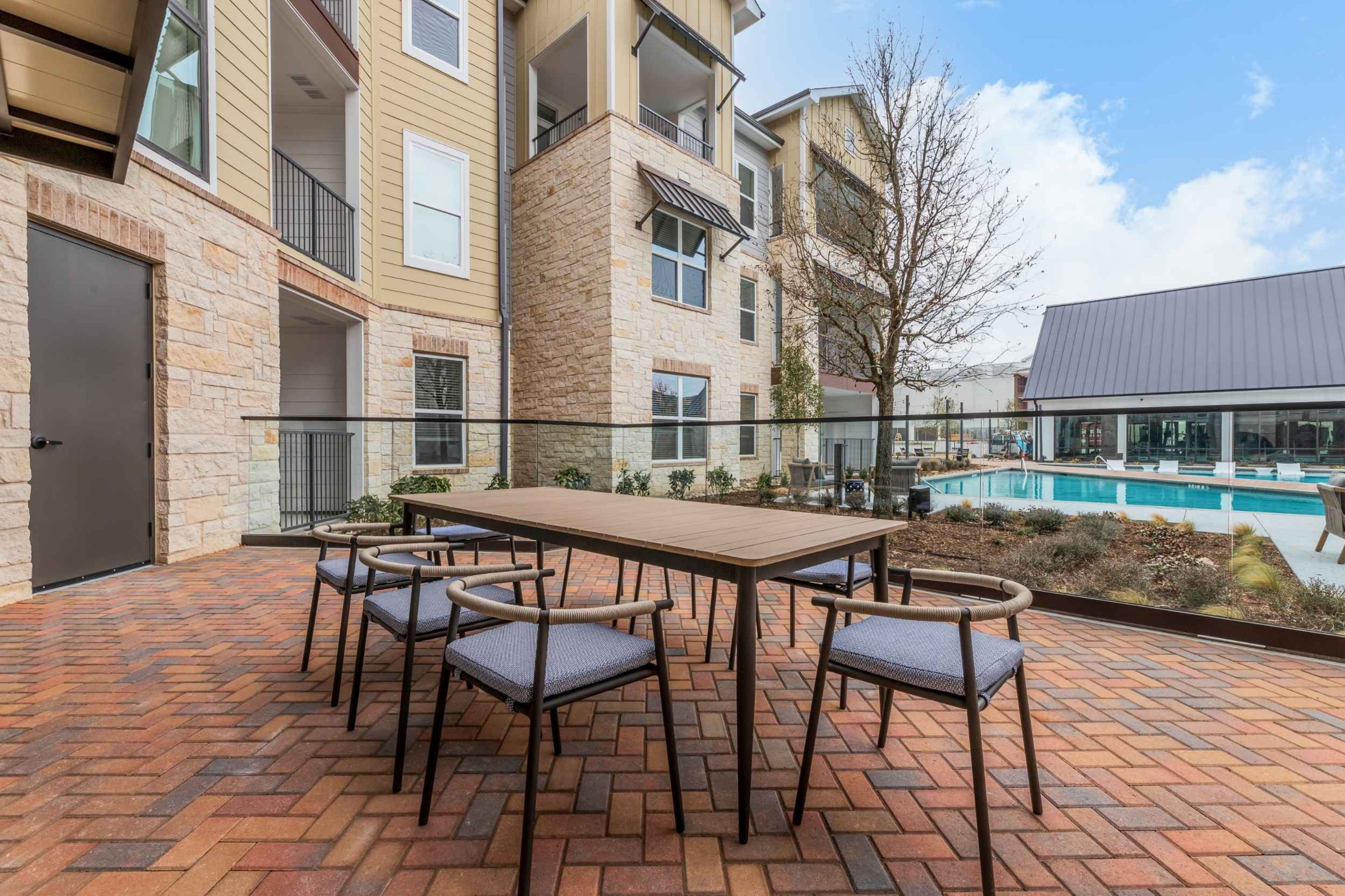 Atlas Crown - Poolside outdoor picnic area with a long table and chairs