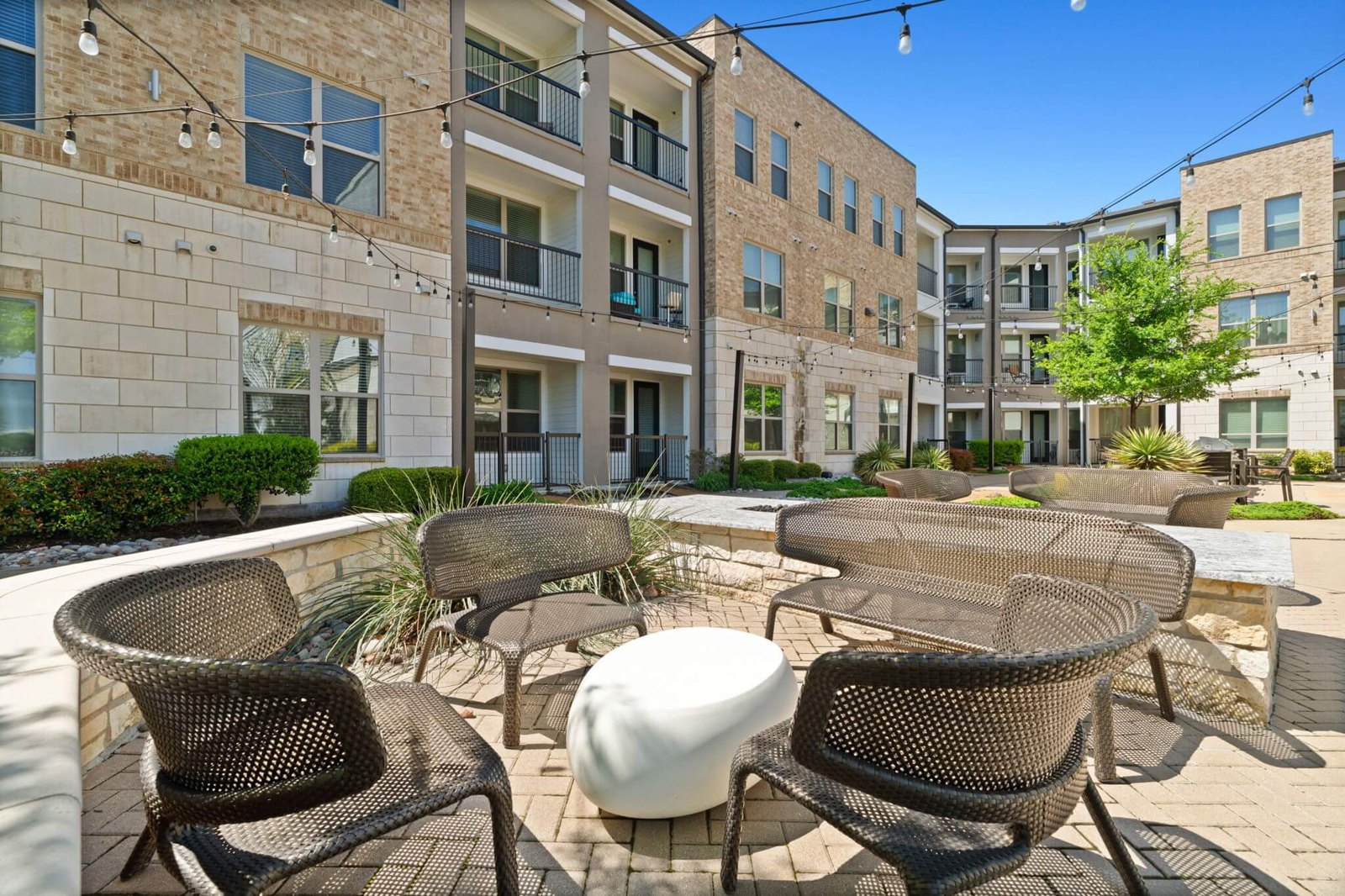 A patio with chairs and a table in front of a building. at Axis at Watters Creek