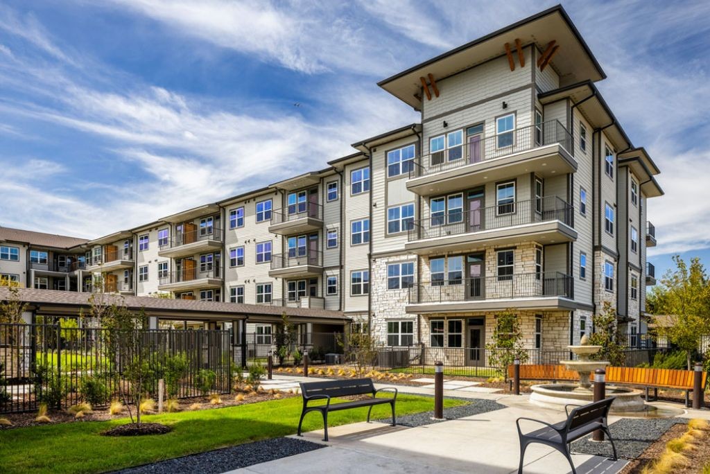 Affinity at Lewisville - Building exterior with landscaped walkways and benches