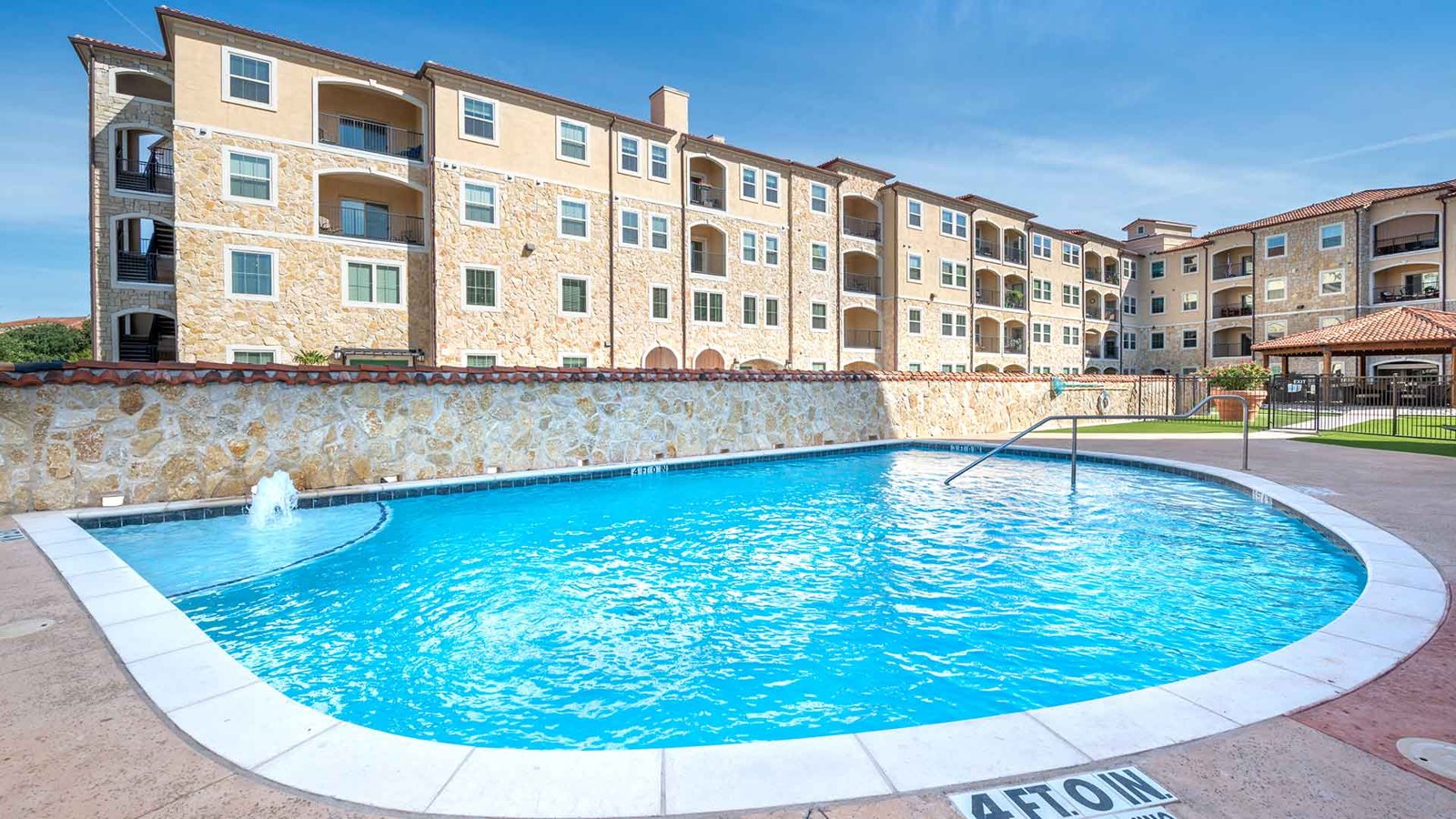 Standing before the pool with the apartment building in the background and the gazebo to the far right. at Bell Tower Reserve