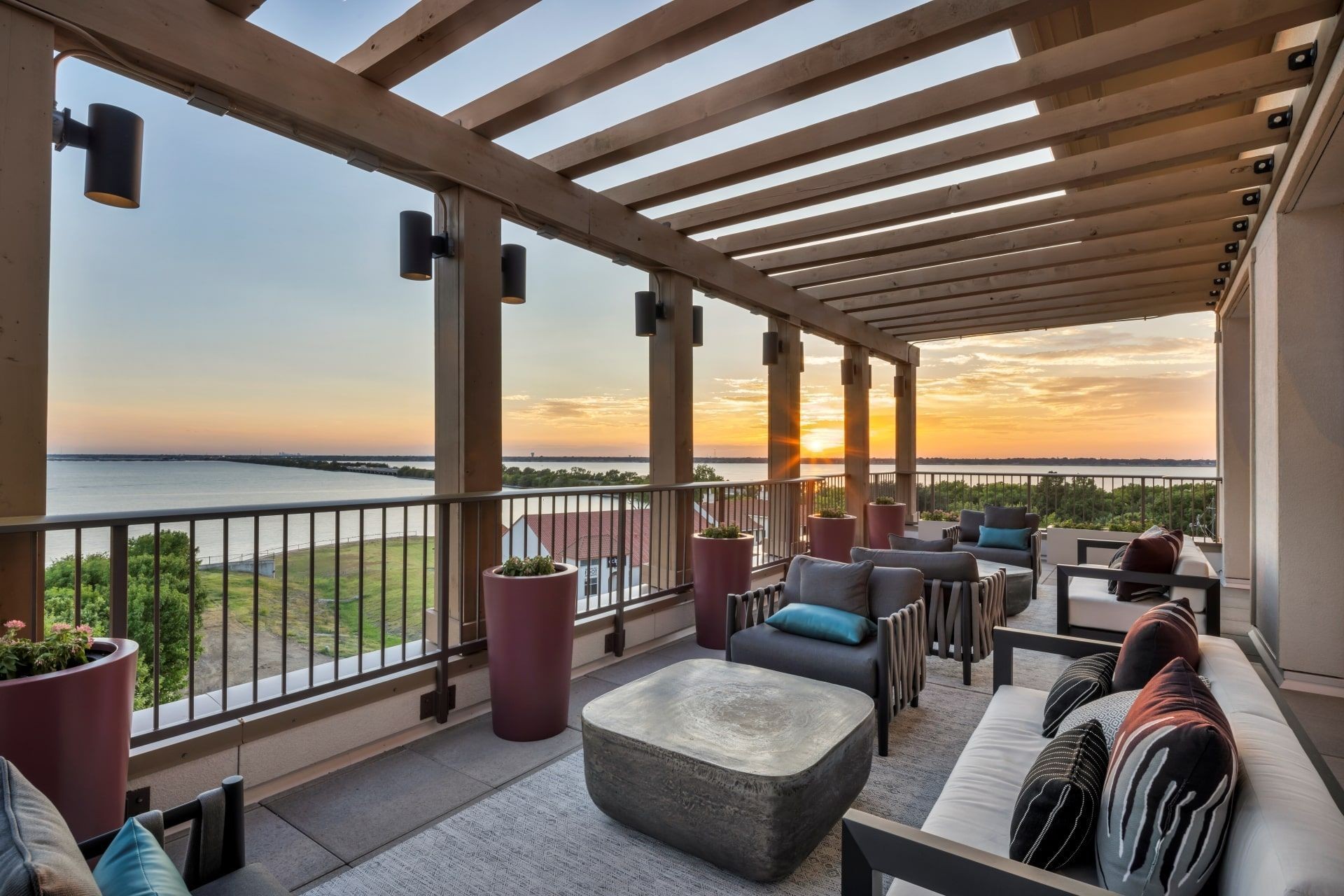 Ablon at Harbor Village - Outdoor balcony lounge with couches and chairs and a sunset view
