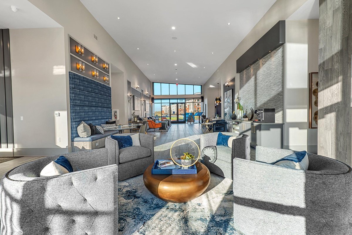 A modern living room with a large grey sofa and a coffee table. at Axis Grand Crossing