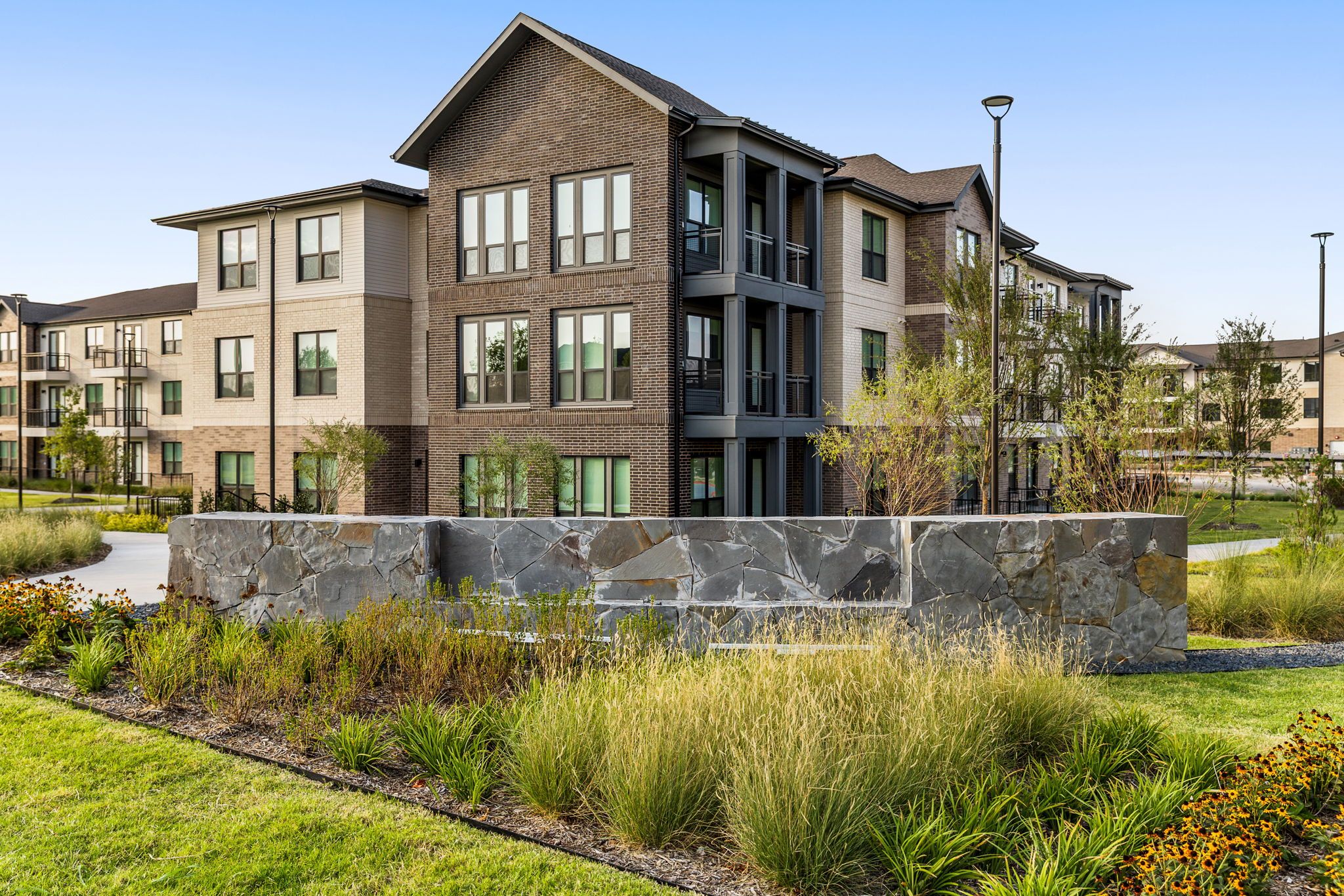Avina at the Grove apartment building exterior with landscaping