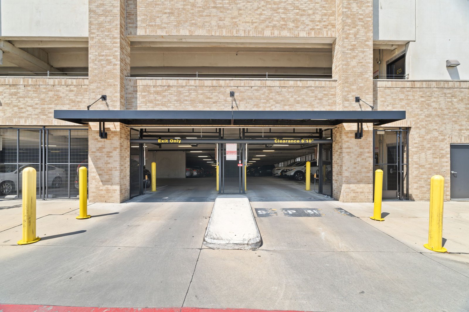 A parking garage entrance with a sign th at Axis at Watters Creek