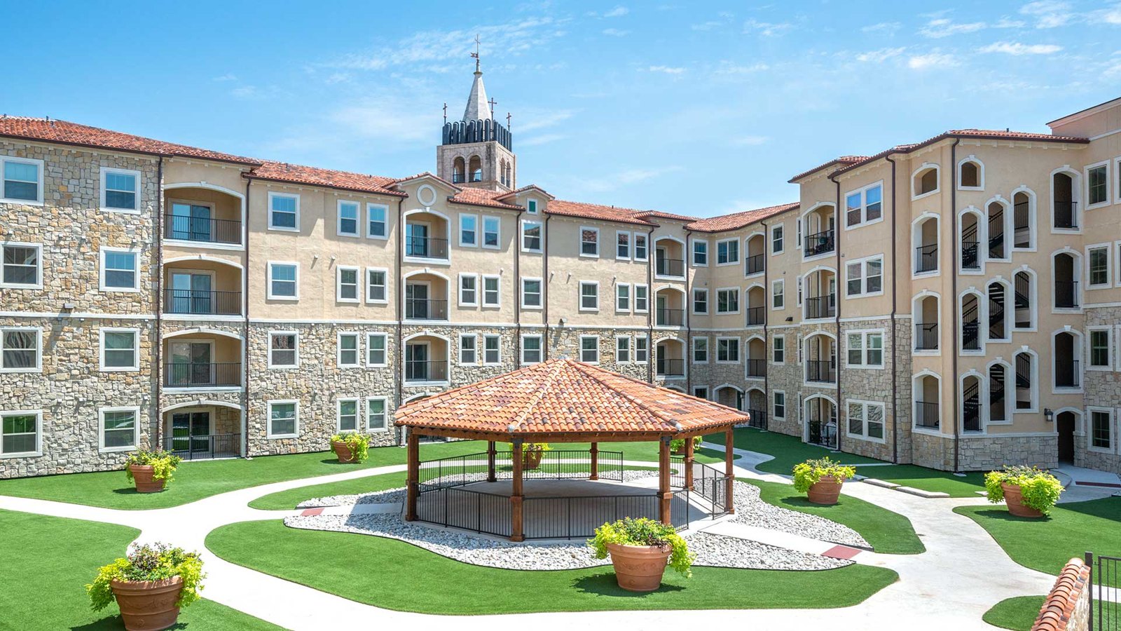 The cabana in the courtyard of Bell Tower Reserve, the apartment building surrounding it behind on a sunny day. at Bell Tower Reserve