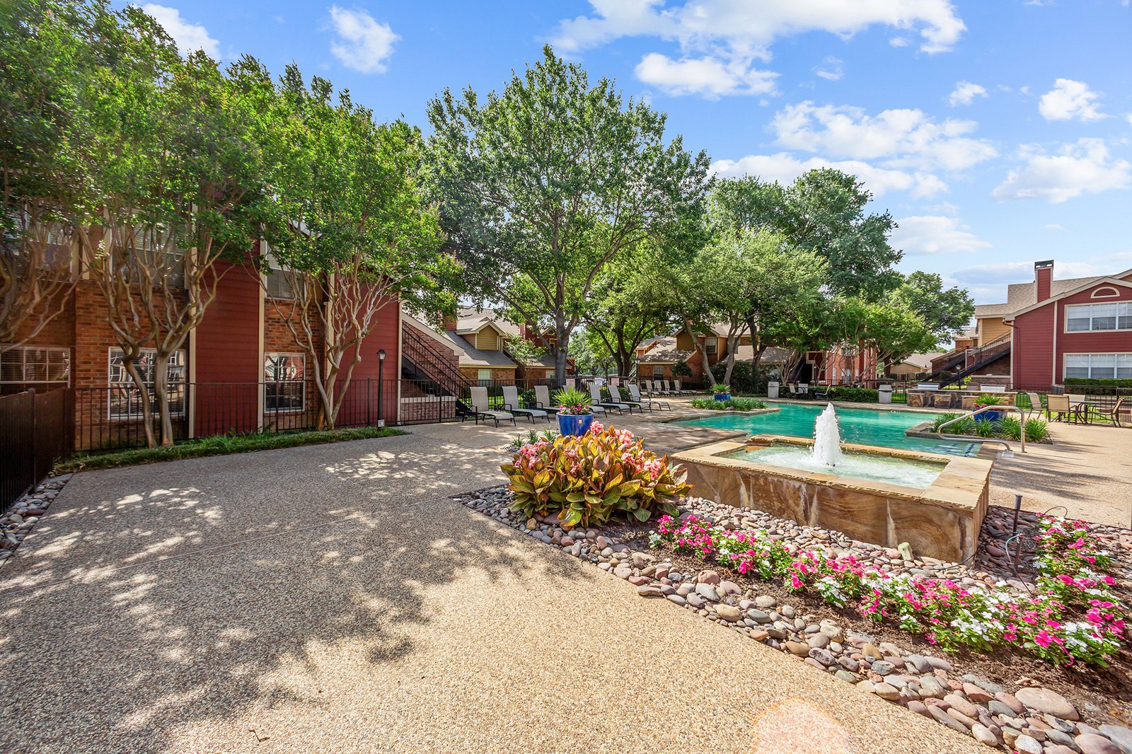 A residential area with a pool and a garden. at Bravo Apartment Living