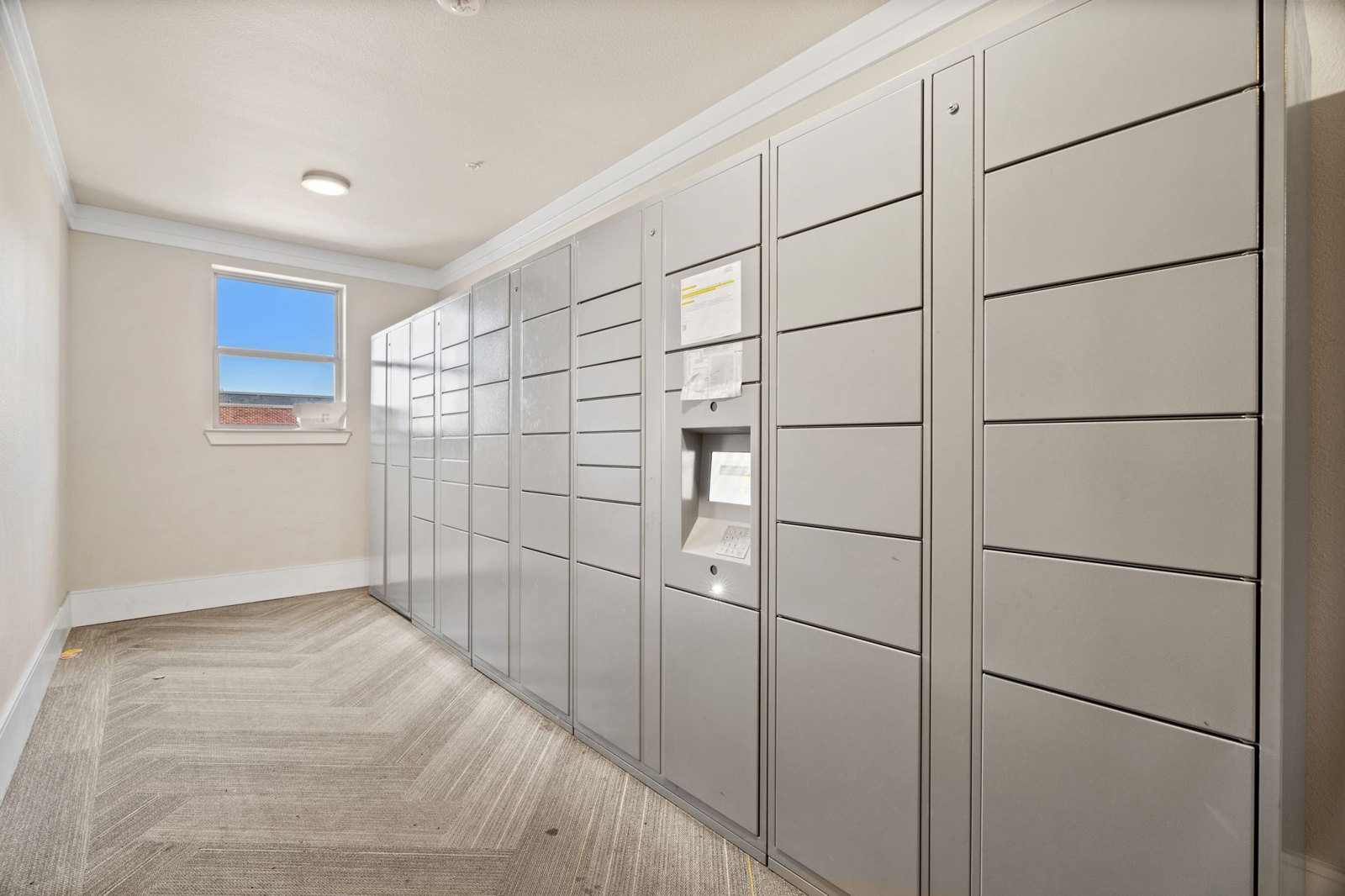A hallway with a row of lockers on the right side. at Axis at Watters Creek