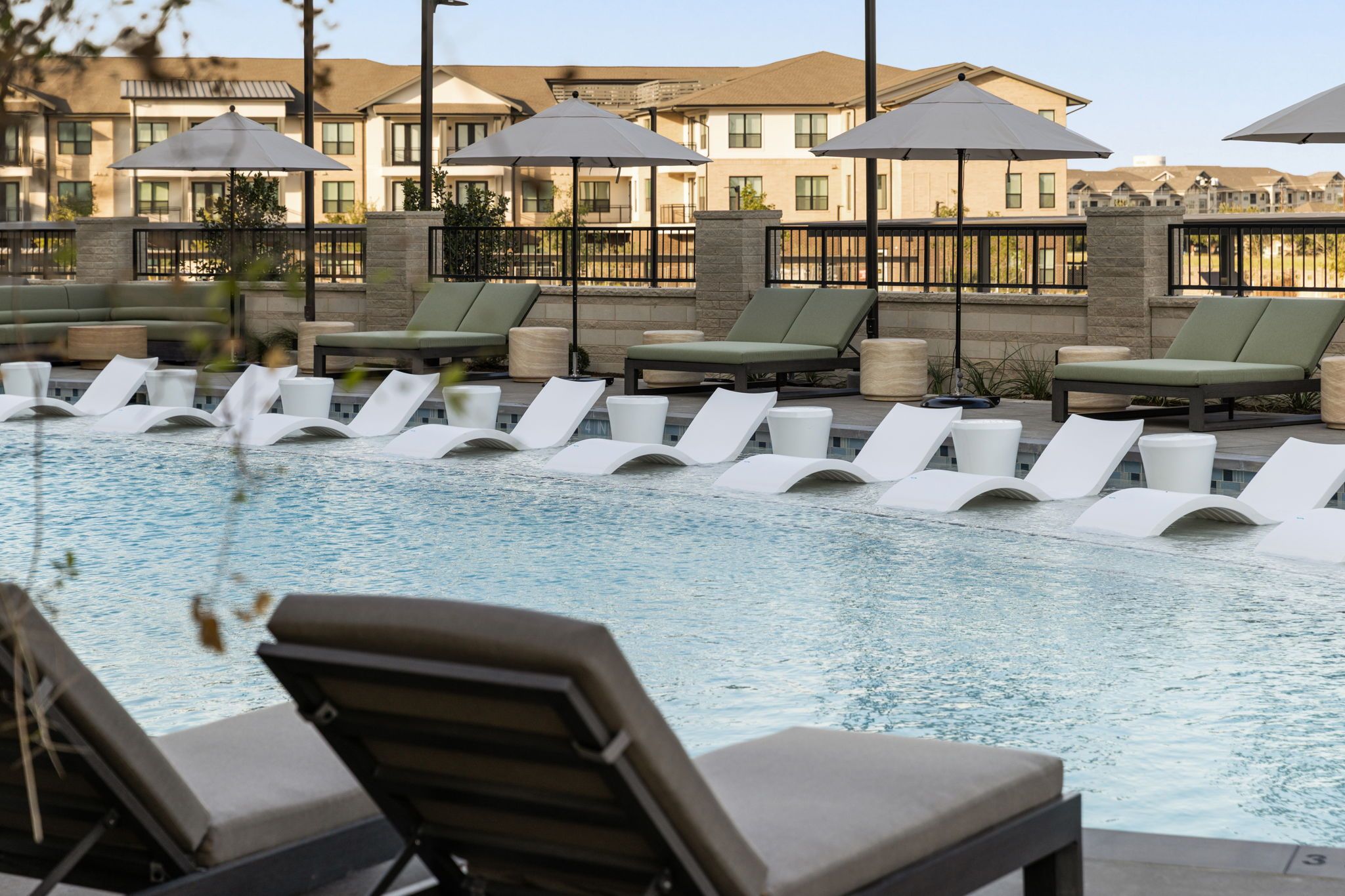 Pool deck with in-water loungers and umbrellas