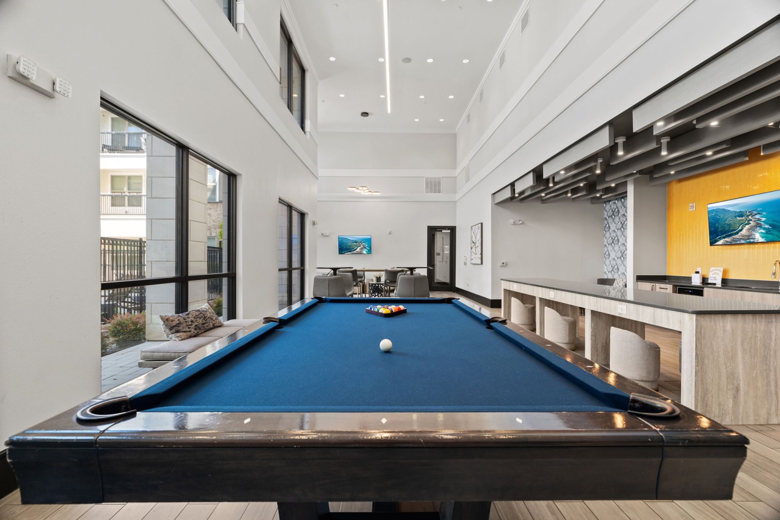 A pool table in a room with a bar area. at Axis at Watters Creek