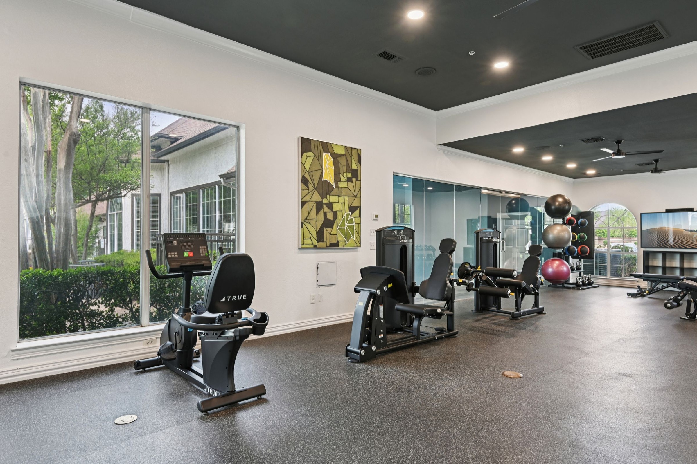 23Hundred at Ridgeview - A modern gym area with exercise equipment and large windows letting in natural light