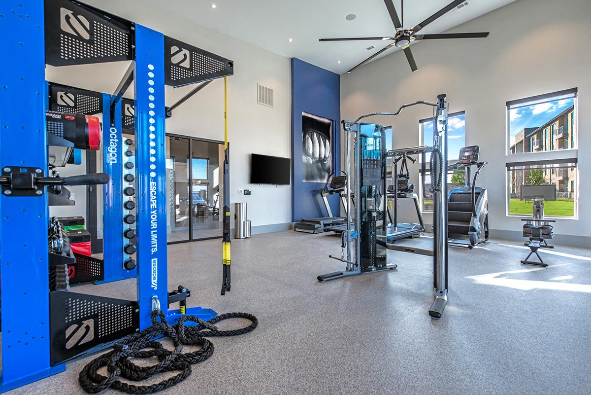 A gym with a variety of equipment including a weight rack, treadmill, and exercise bike. at Axis Grand Crossing