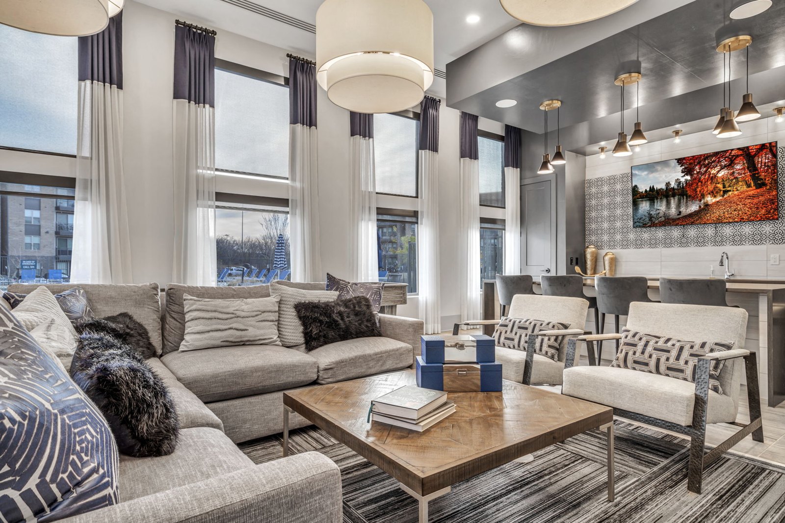 A modern living room with a grey sofa, a wooden coffee table, and a large painting on the wall. at Axis Grand Crossing