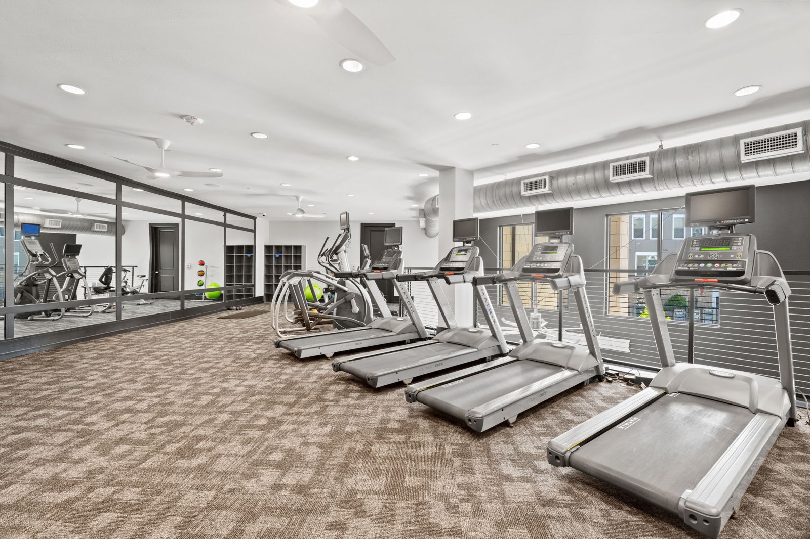 A gym with treadmills and other exercise equipment. at Axis at Watters Creek