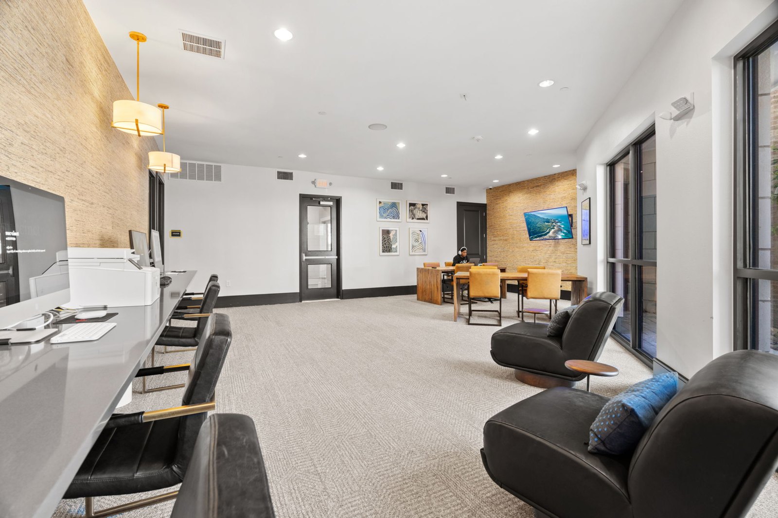 A waiting area with black leather chairs and a white reception desk. at Axis at Watters Creek