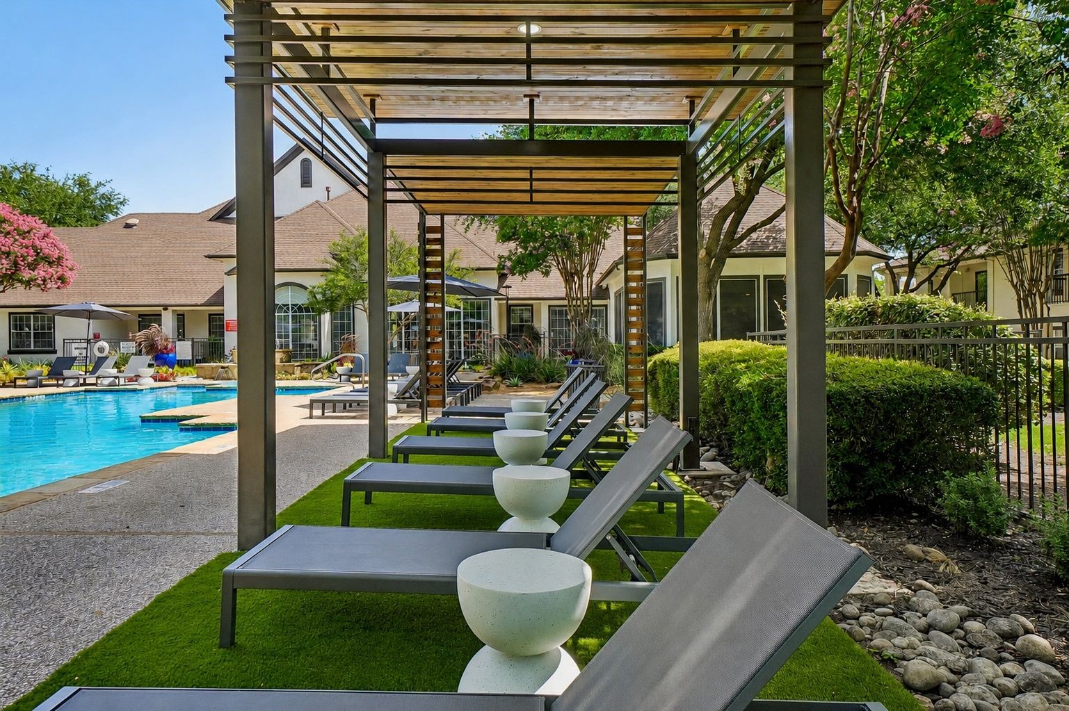23Hundred at Ridgeview - A serene poolside area with lounge chairs and lush landscaping