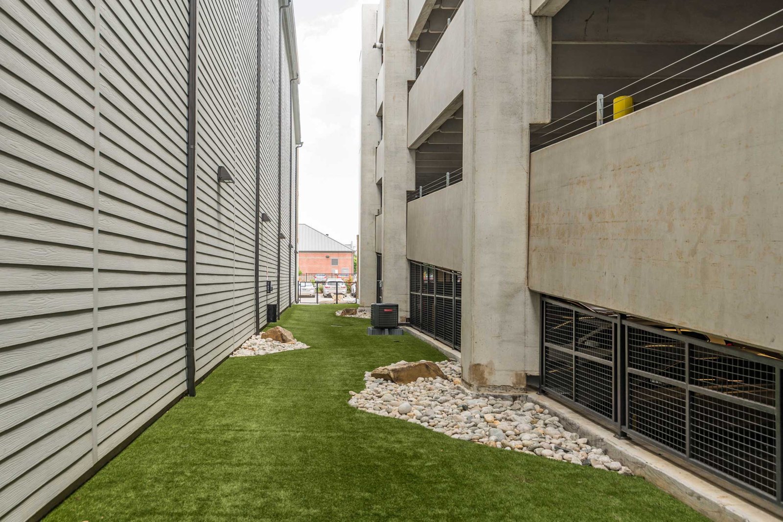 A concrete building with a green lawn in front. at Axis at Watters Creek