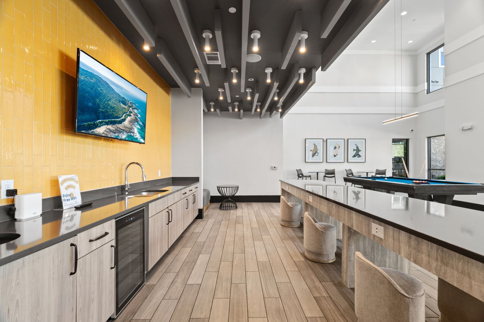 A modern kitchen with a long counter and a painting hanging above it. at Axis at Watters Creek