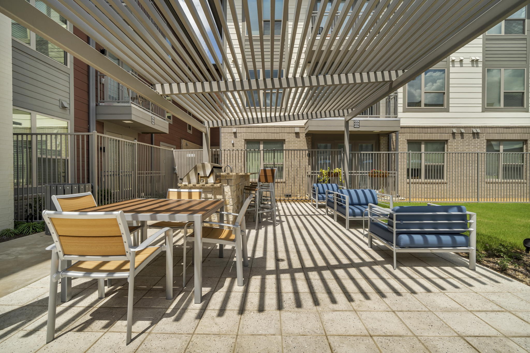 26 at City Point - A patio with a table and chairs under a striped awning