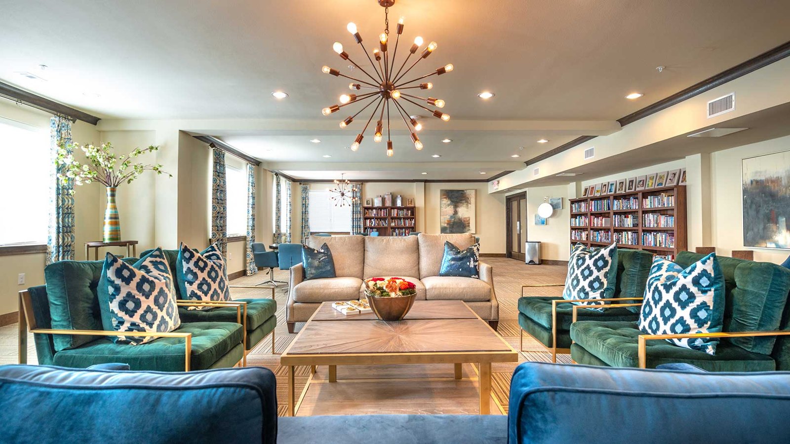 Four plush coaches face other around a large coffee table. There are shelves along the walls with games and more. at Bell Tower Reserve