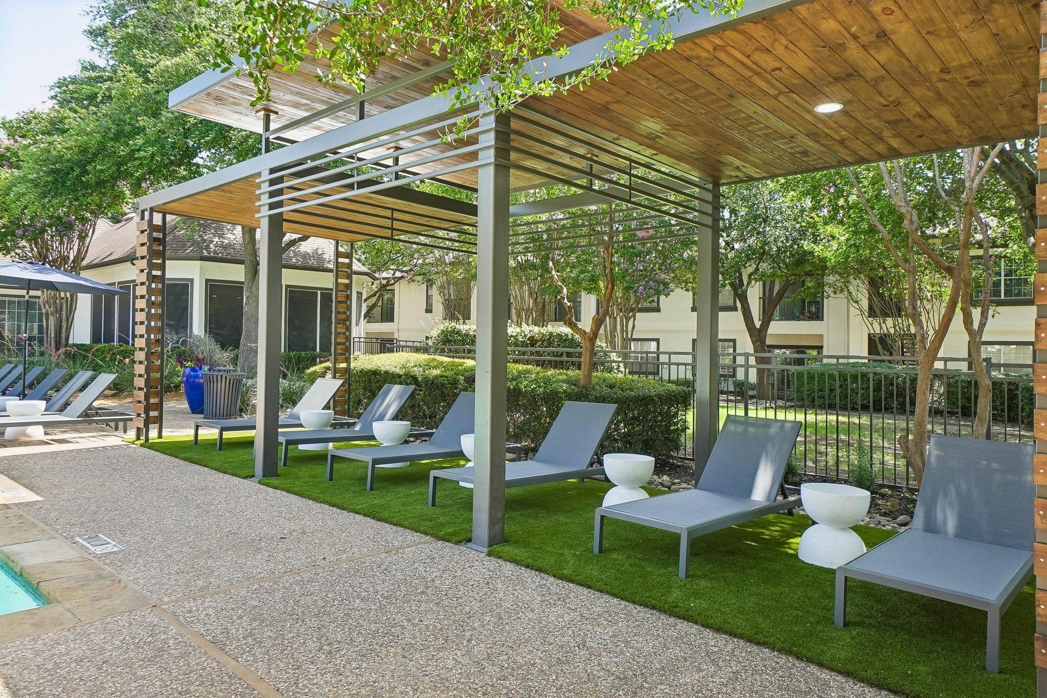 23Hundred at Ridgeview - Relaxing outdoor area with lounge chairs and shaded seating by a pool
