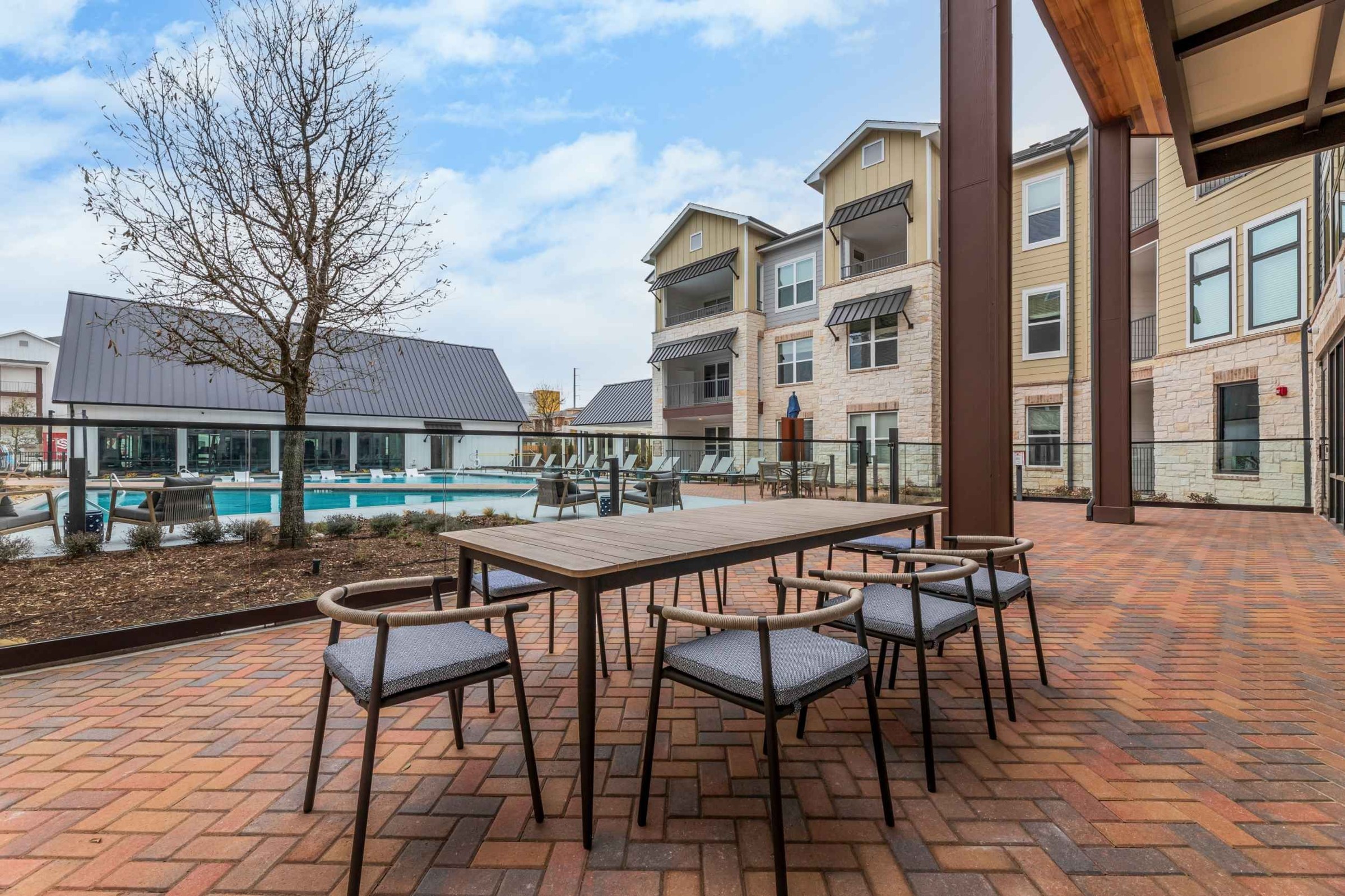 Atlas Crown - Poolside outdoor picnic area with a long table and chairs