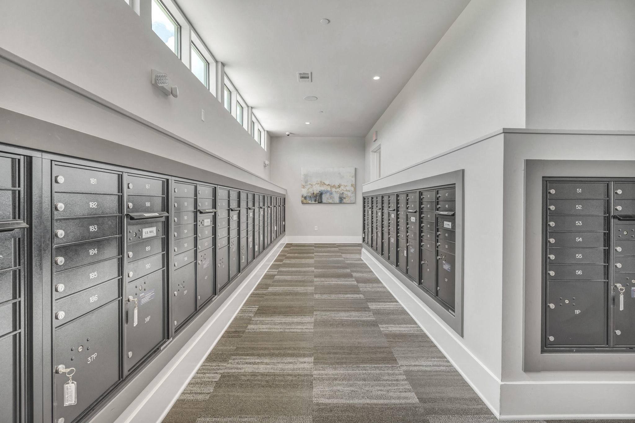 26 at City Point - A long hallway with a carpeted floor and a series of lockers on both sides