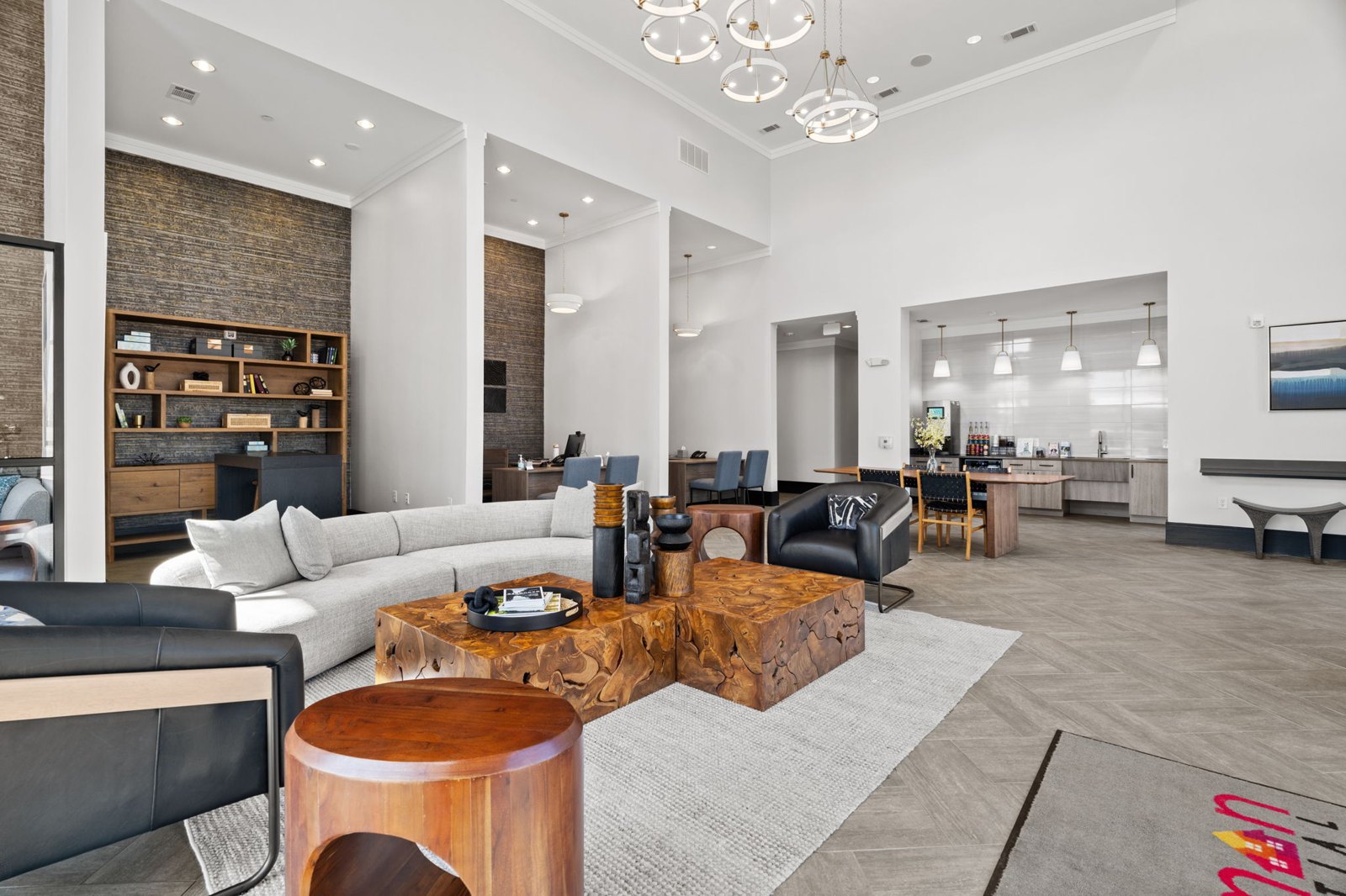 A modern living room with a wooden coffee table and a black leather couch. at Axis at Watters Creek