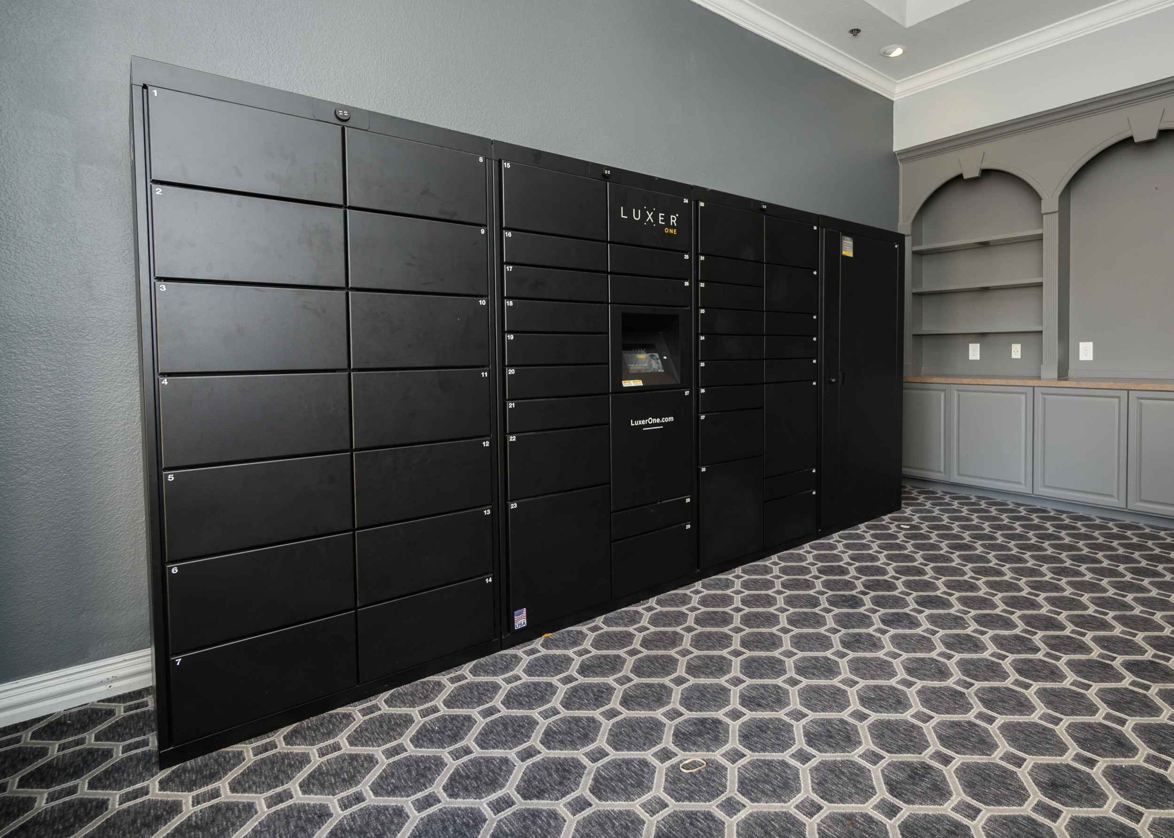 23Hundred at Ridgeview - A sleek black package delivery locker system in a modern setting with patterned flooring