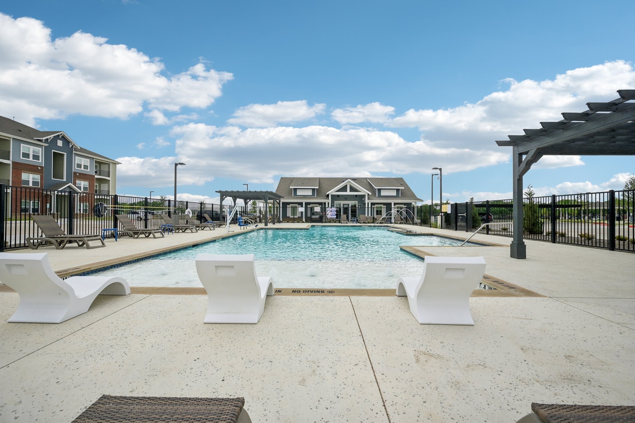 Swimming pool with splash pad and loungers
