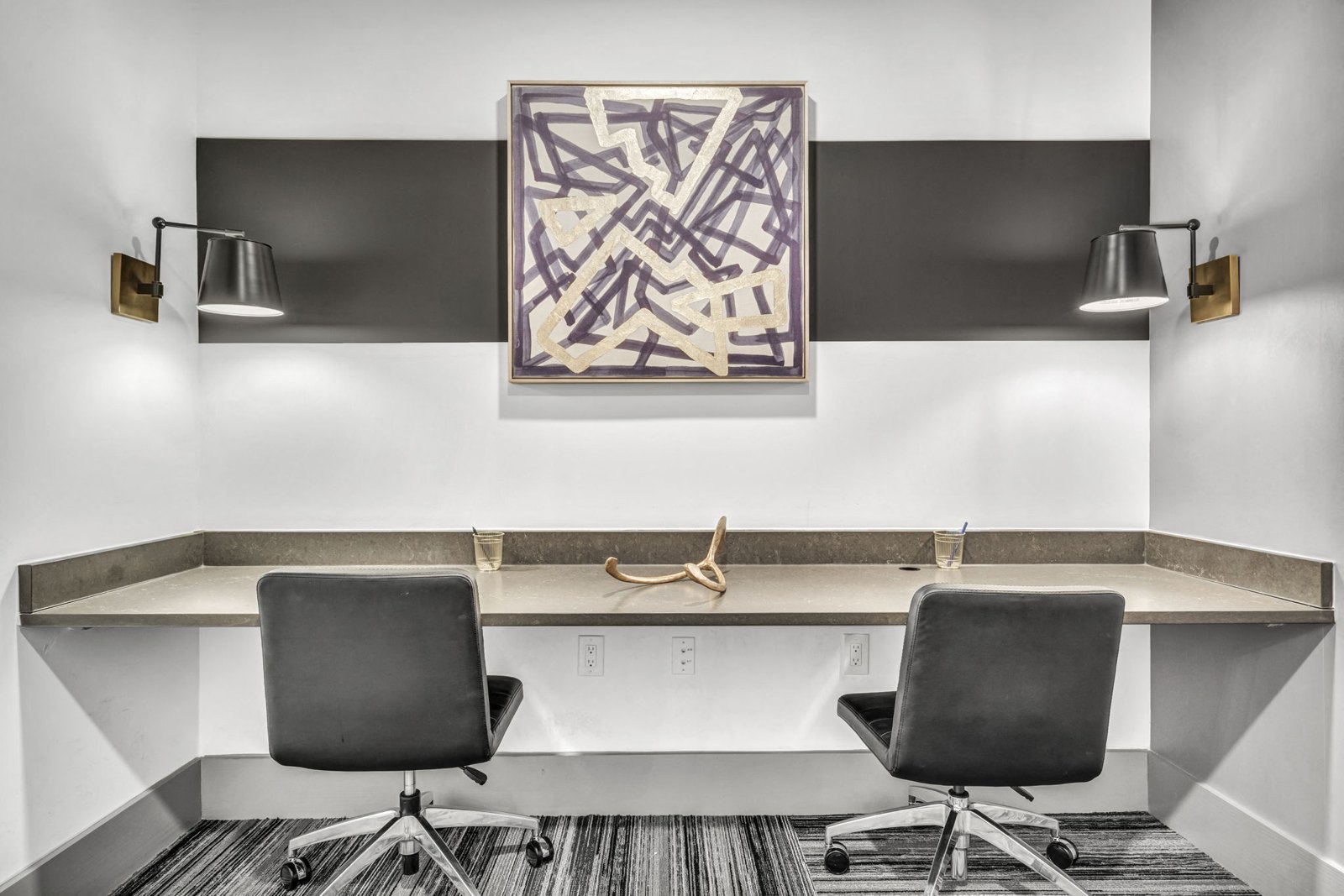 A modern office with a large abstract painting on the wall. at Axis Grand Crossing
