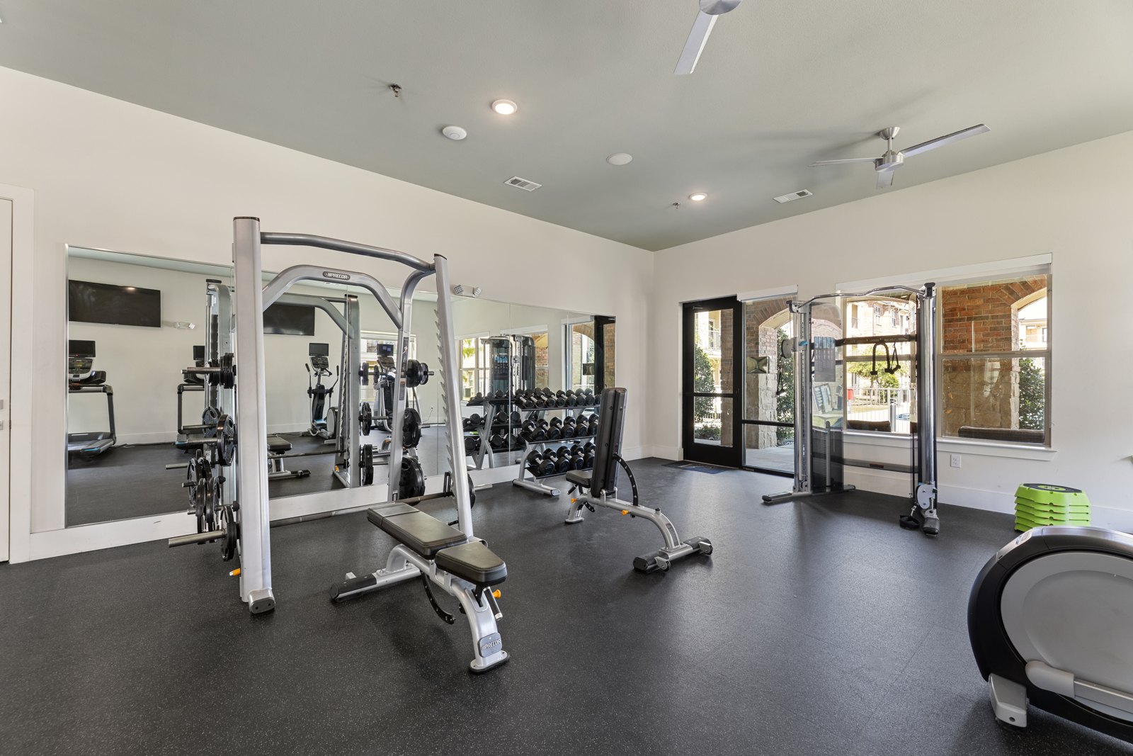 A spacious gym with a variety of equipment including a squ at Auberge of Burleson