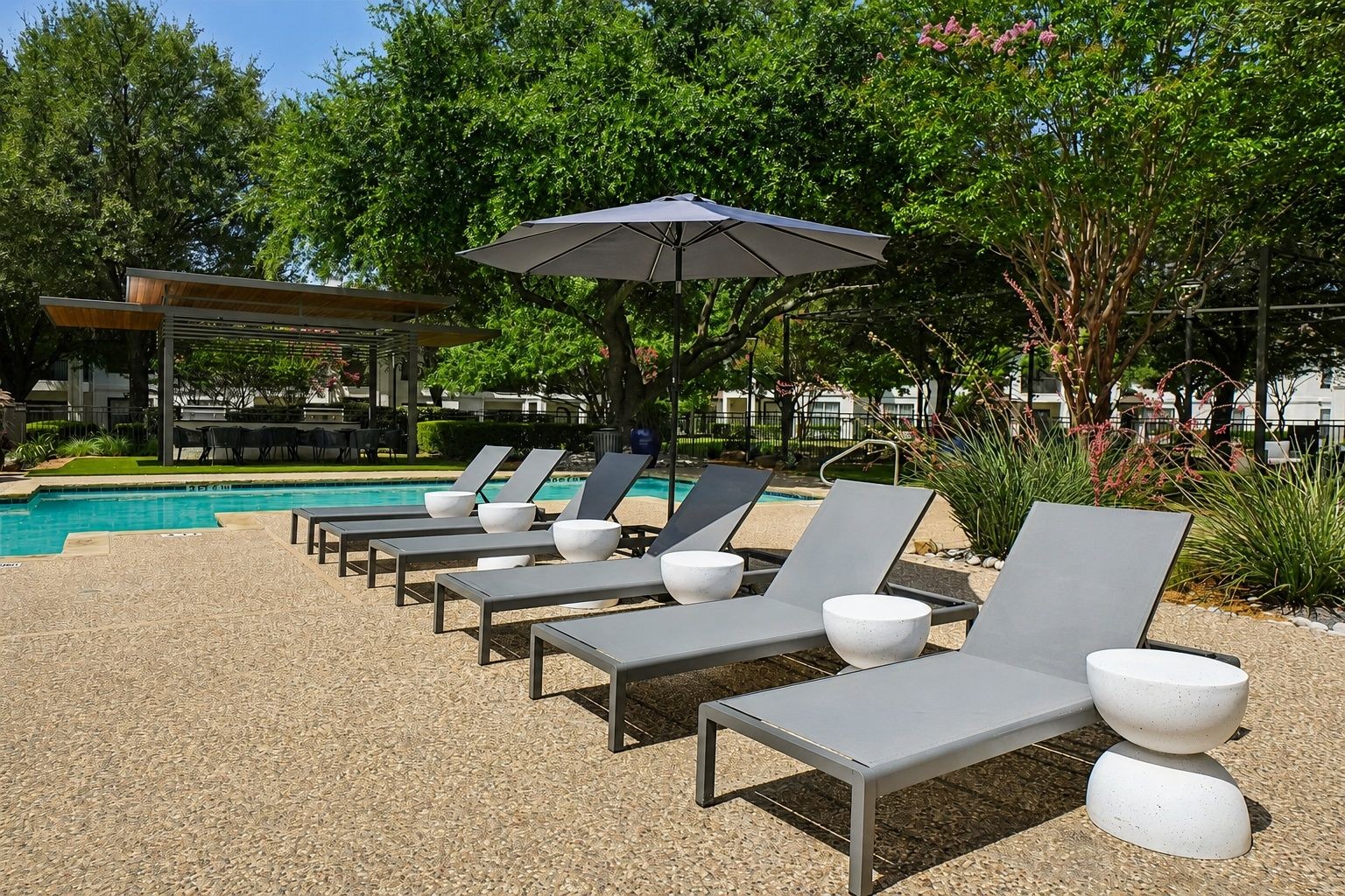 23Hundred at Ridgeview - Lounge chairs by a pool surrounded by trees and an umbrella
