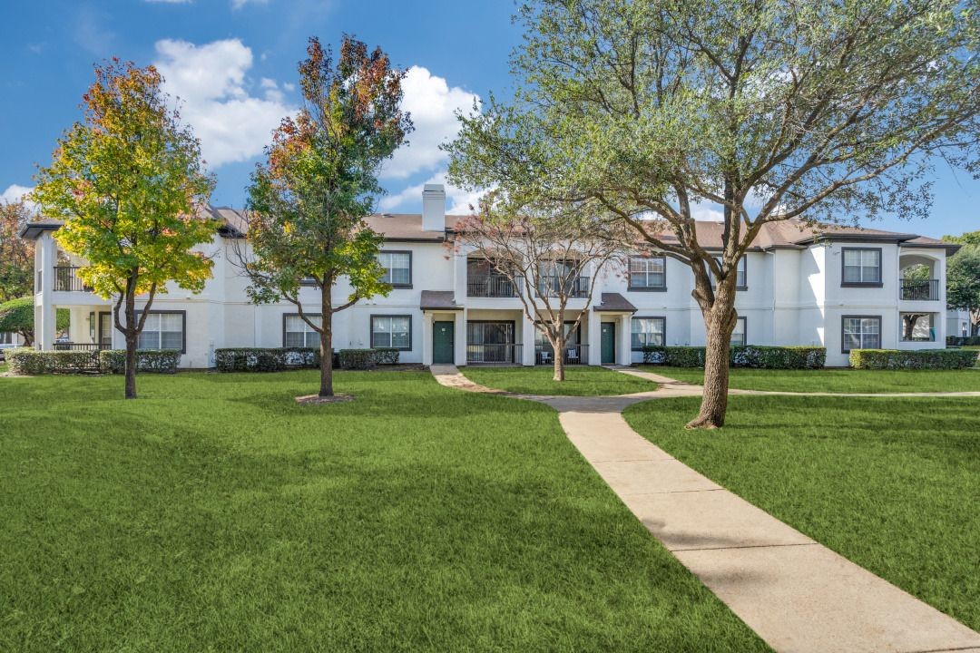 23Hundred at Ridgeview - concrete walkway through grass and trees leading to apartment building