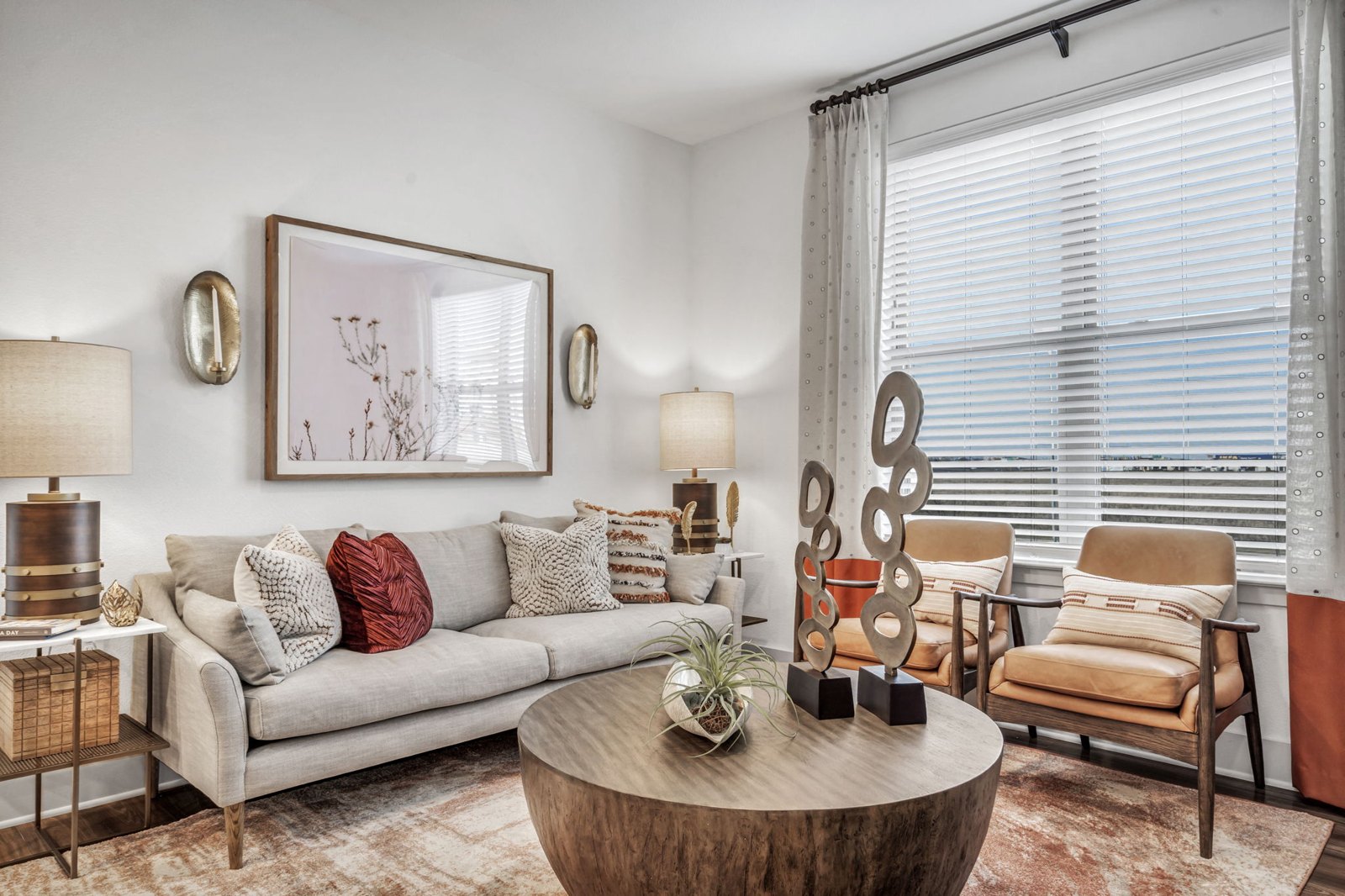 A living room with a grey couch, a wooden coffee table, and a painting on the wall. at Axis Grand Crossing